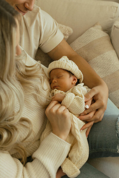 newborn in mom and dads arms