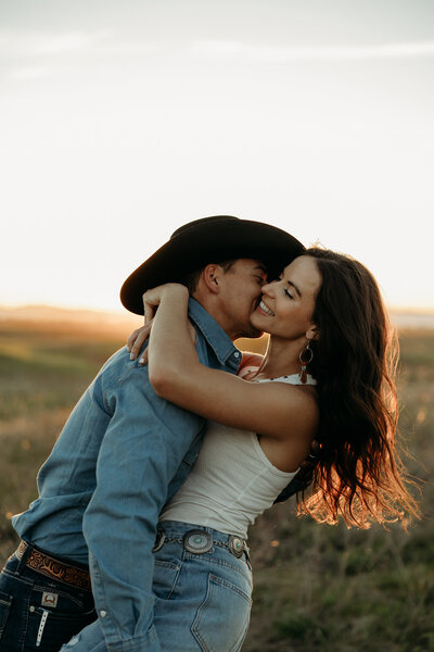 a couple posing in front of a grand montana sunset