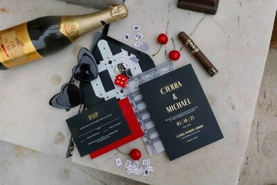 George Peabody Library wedding invitations laid on museum floor with cherries, dice, cigars as props