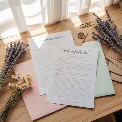 Flat lay of printable creativity worksheets and a pen on a wooden desk with lavender sprigs, softly lit by a window.