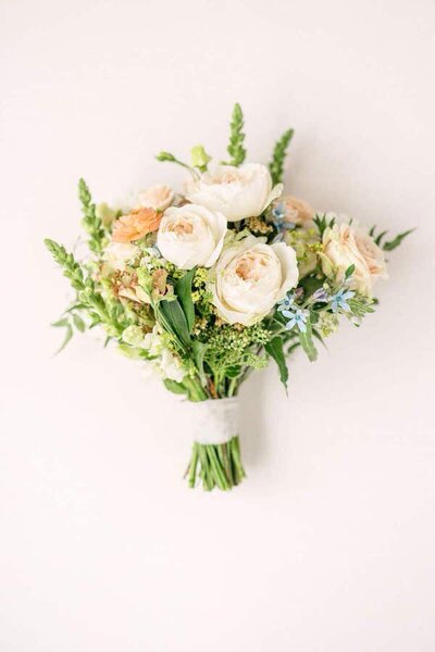 Wedding bouquet of a bride laying flat on the ground as a Calgary wedding photographer photographs her flowers