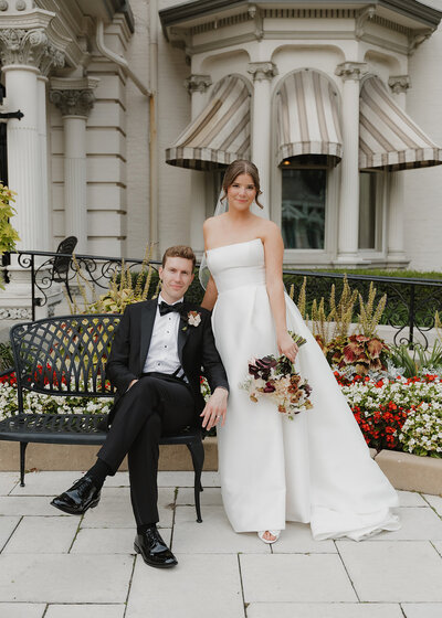 A bride and groom posing in front of the Wisconsin Club in Milwaukee.