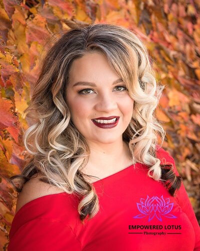 red lips to match her red dress infront of fall leaves