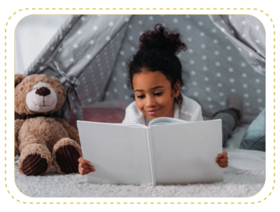 black girl reading in tent with teddy bear