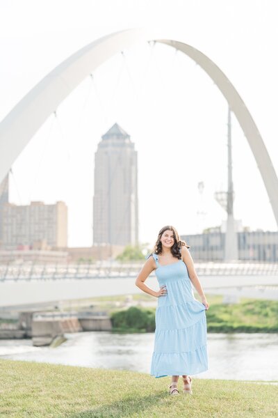 a high school girl wearing a light blue dress standing under an archway