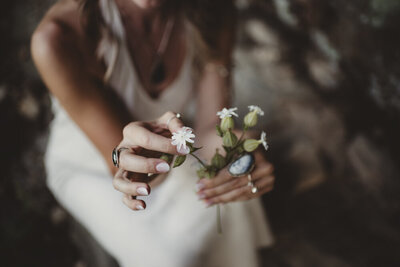 Soft image of Caroline Weiss holding flowers, reflecting peace, femininity, and emotional healing