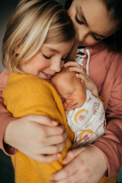 Sisters holding newborn
