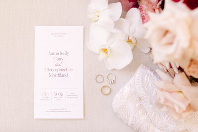 Wedding rings and invitation suite styled on a soft linen background, captured as an elegant flatlay detail at an intimate backyard wedding in Richmond, Virginia.