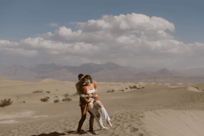 Man playfully picking up his partner in the sand dunes of Death Valley