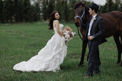 colorado elopement planning guide - bride and groom walk horse in field during wedding photos
