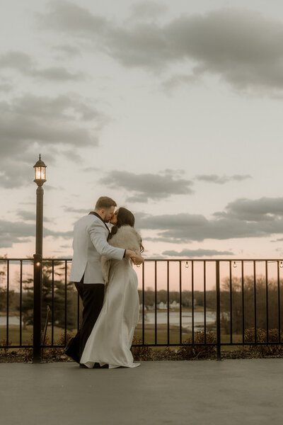 Two grooms kissing in a meadow