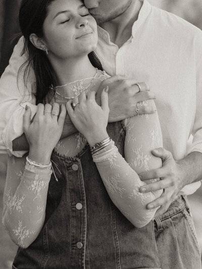 fiance kissing his love on the cheek, her eyes closed