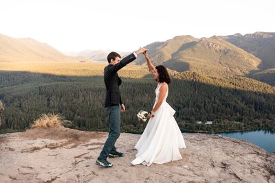 brides are walking hand in hand while holding bouquets along a dirt road