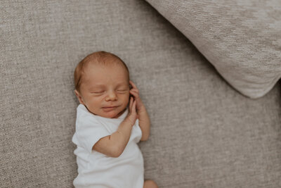 Premature baby cuddled on the couch for newborn session in Warrenville, IL