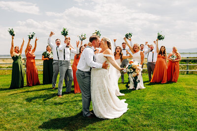 Bride and groom kissing with wedding party at U Diamond Barn in Helena, MT