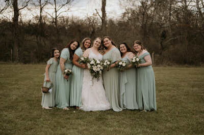 BRIDAL PARTY HOLDING BOUQUET ON MOODY WEDDING DAY