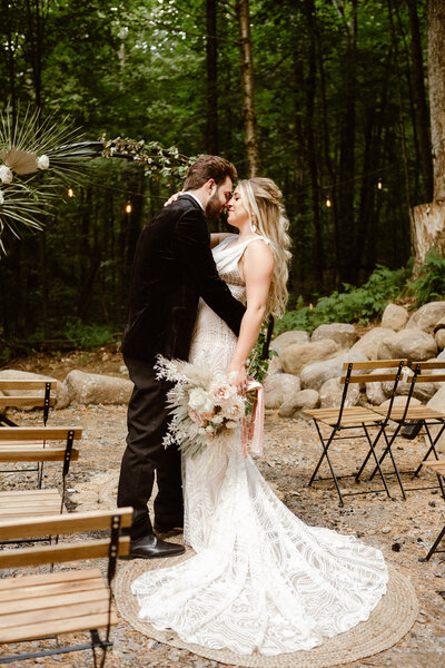 Bride and groom embrace in the ceremony aisle during their Virginia forest elopement.