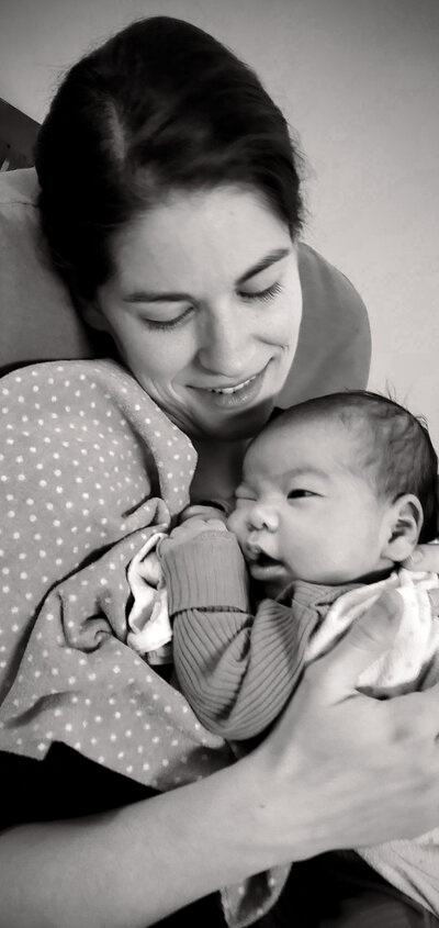 rebeca yasuda smiling at newborn baby