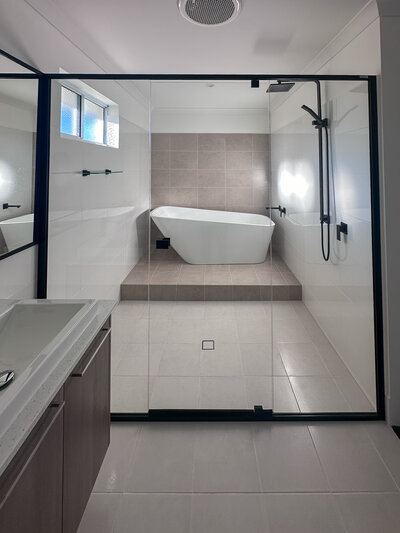 Modern bathroom with raised bath at one end 