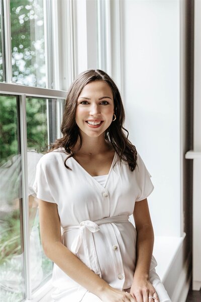 Wedding Coordinator Sarah smiles in a white dress