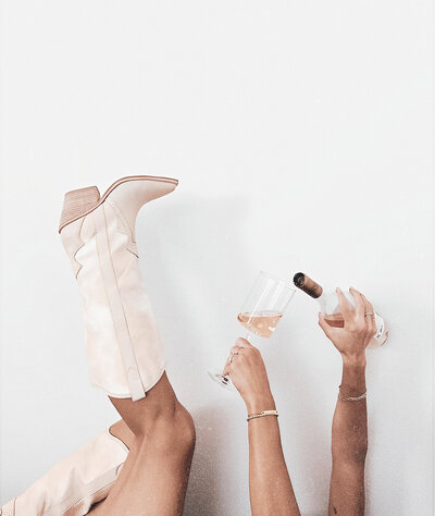 Photo of Boots and Champagne in a glass celebrating business goals. 