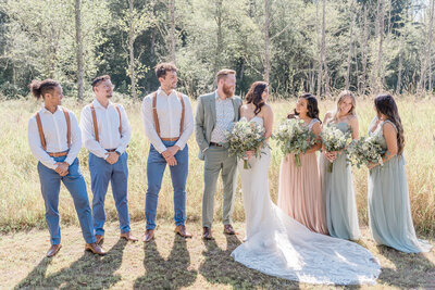 bride and groom posing with bridal party