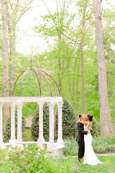 Gramercy Mansion Wedding Photographer snaps a photo of a bride and a groom in front of the Gramercy Mansion gazebo