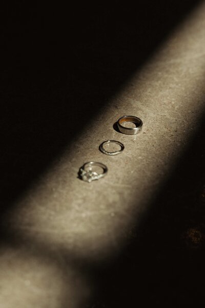 three rings styled in a ray of sunlight through a charlotte window