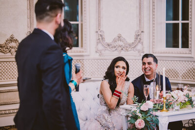 Indian bride crying tears listening to a speech during the wedding reception