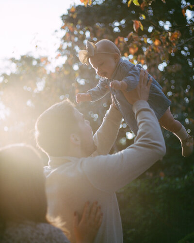 couple holds baby daughter in glowing sunlight by huntsville photographers fauna & film