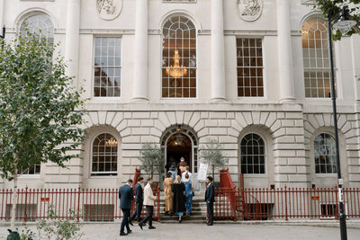 Guests arriving at Old Sessions House with red iron gates and white neoclassical facade.