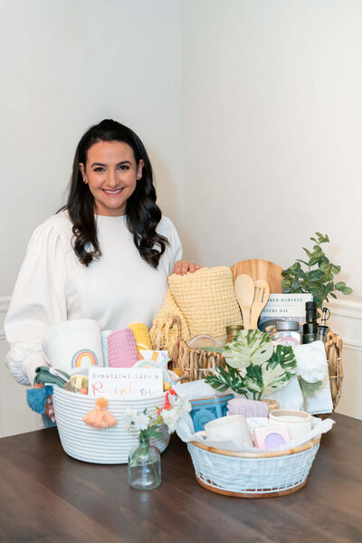 Aubrey of Graciously Gifted Standing with three curated gift baskets