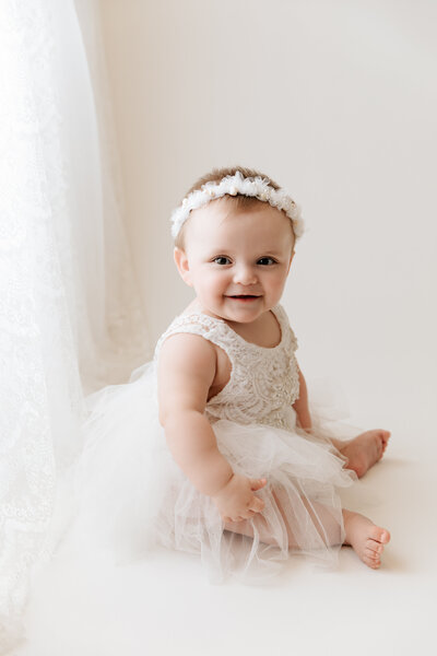 newborn baby girl dressing in pink with a fur rug during her newborn session