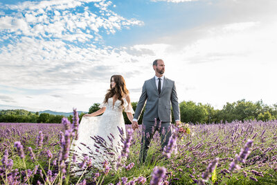 Wedding photo in lavender field as bride and groom look off in opposite directions by Allison Burton Photography