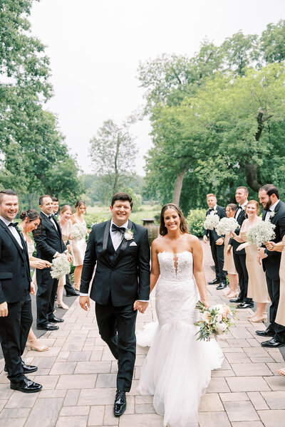 Bride and groom walk down aisle together with bridal party at Willows at Ashcombe.