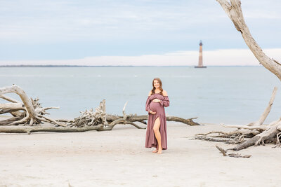 mom holding her baby bump at the beach