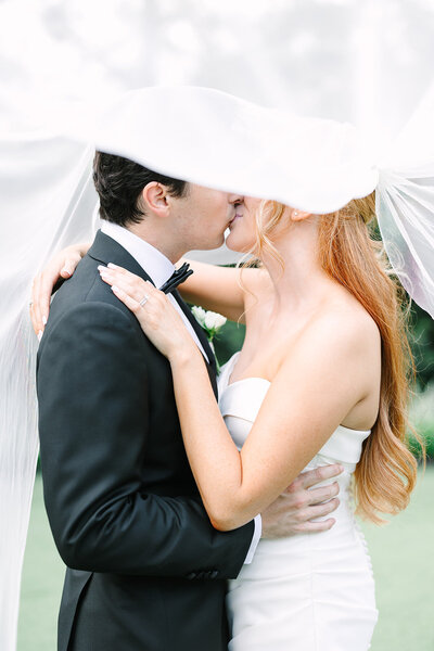 Beautiful bride in satin wedding dress with long veil