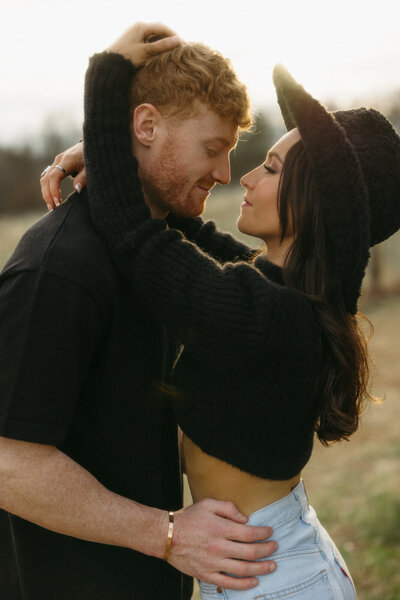 Couple embracing each other in the golden glow of sunset on a ranch with Western Inspiration similar to Montana and Wyoming, by Andrea-Marie Photography