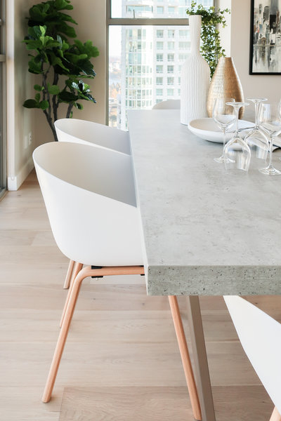 concrete dining table with white bucket chair
