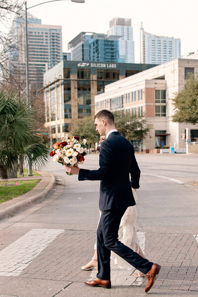Bride and groom downtown Austin crossing the street
