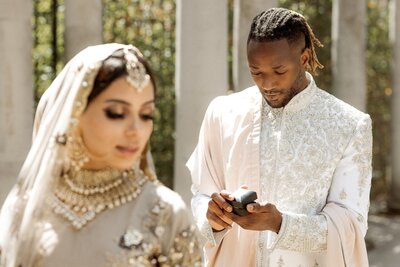 Man looking at a wedding ring in his hand before proposing to his future wife to be  during a surprise photography in pergola and hill garden Hampstead