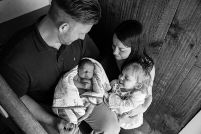 Black & White photo of family with Newborn baby sitting on stairs | Newborn session