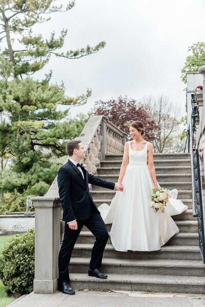 bride and groom walking down the steps off of the terrace at villa terrace in milwaukee wisconsin