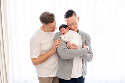 Two dads with their newborn baby girl