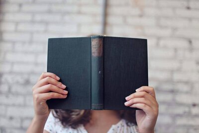 Child reading a book, face hidden — Expat Book Club feature on identity, transition, and misunderstood childhood experiences abroad

