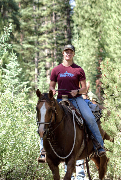 girl in red shirt riding a horse