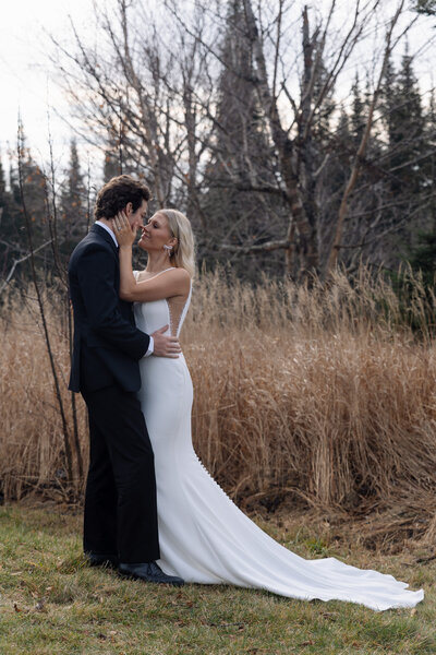 Tall grass frames an intimate moment between an eloping couple in nature. 