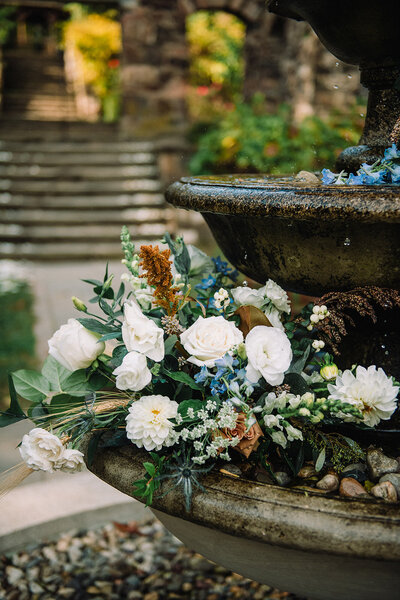 Romantic wedding arch adorned with stunning floral designs by Leigh Florist, showcasing pastel roses, hydrangeas, and cascading greenery in a scenic outdoor ceremony.