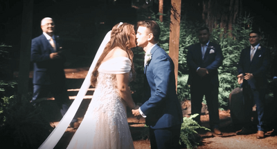 Newlyweds sharing their first kiss at the scenic Waterfall Lodge in Santa Cruz, California.
