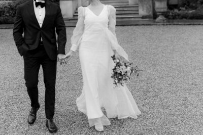 Couple pose powerfully outside of their luxury British manor house wedding venue